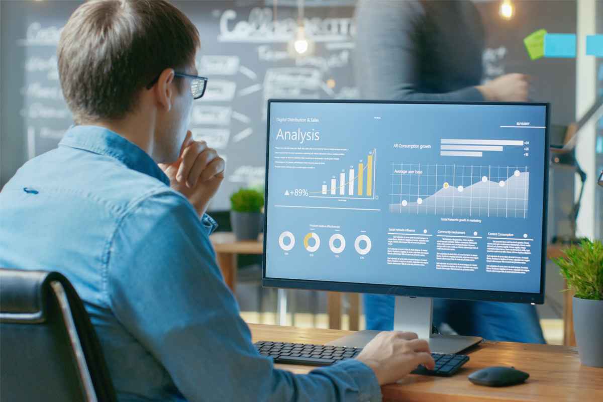 Analyst reviewing digital business performance analysis dashboard on computer