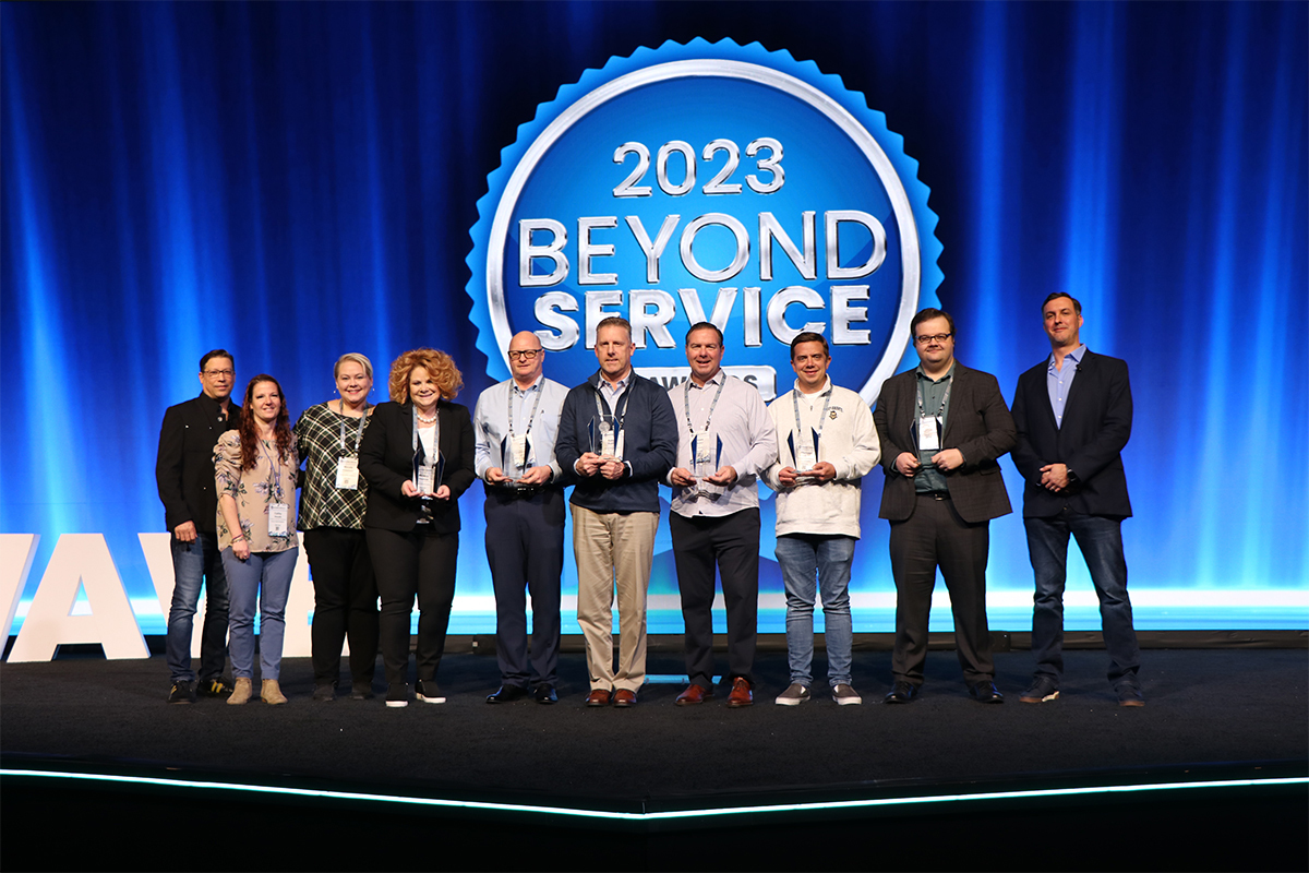 Award recipients pose on stage at 2023 Beyond Service conference