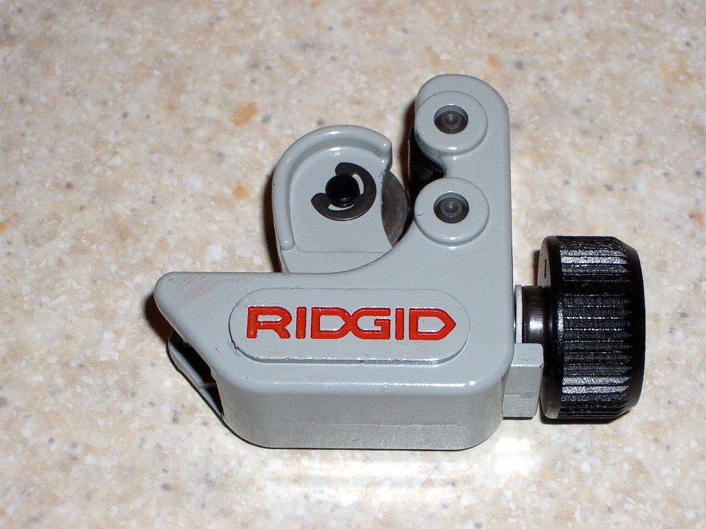 Ridgid pipe cutter tool with multiple cutting wheels in gray