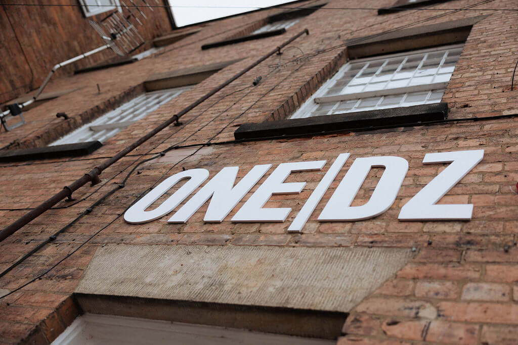Exterior view of ONE|DZ Gym Derby building sign on brick wall