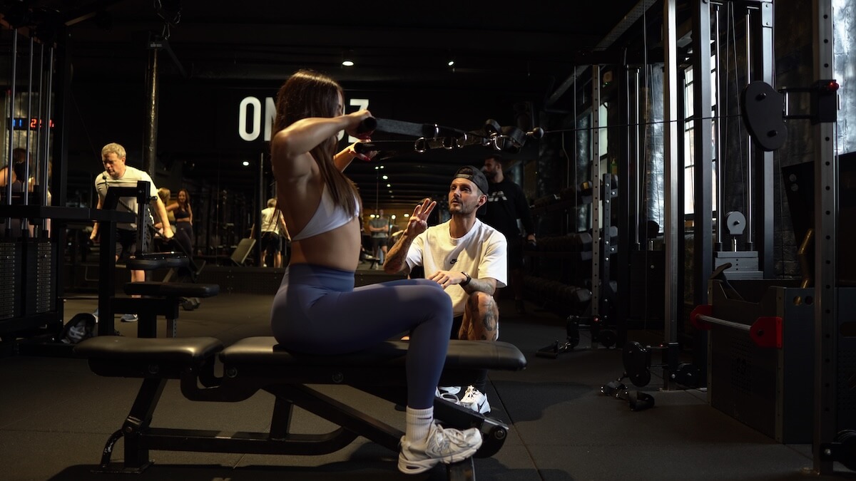 Female client doing lat rows during PT session at ONE|DZ strength gym