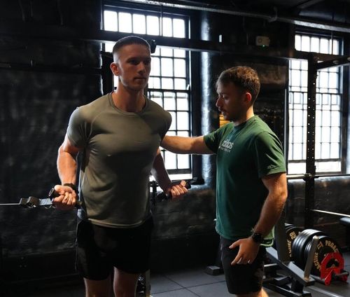 Male client working on cable biceps during personal training session at ONE|DZ Gym Derby