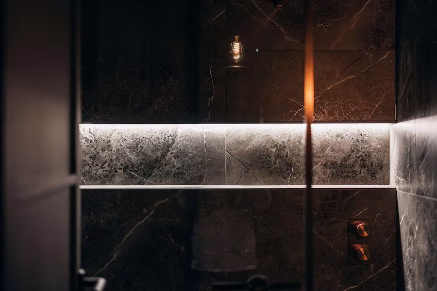 Modern shower area with marble walls at ONE|DZ Gym in Derby