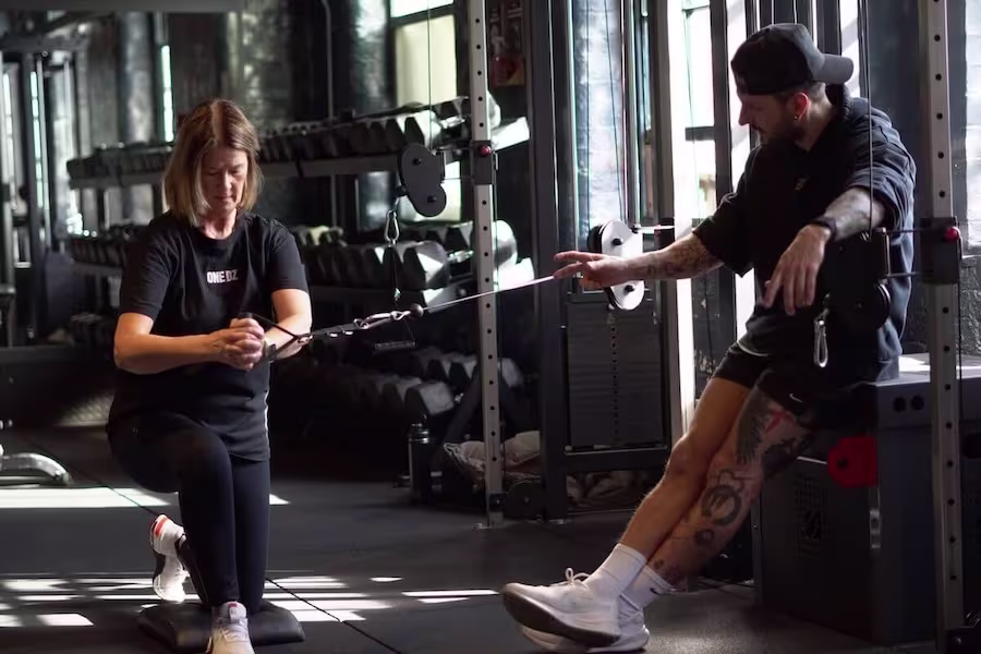 Rehab-style shoulder drill with cable during personal training session at ONE|DZ Gym