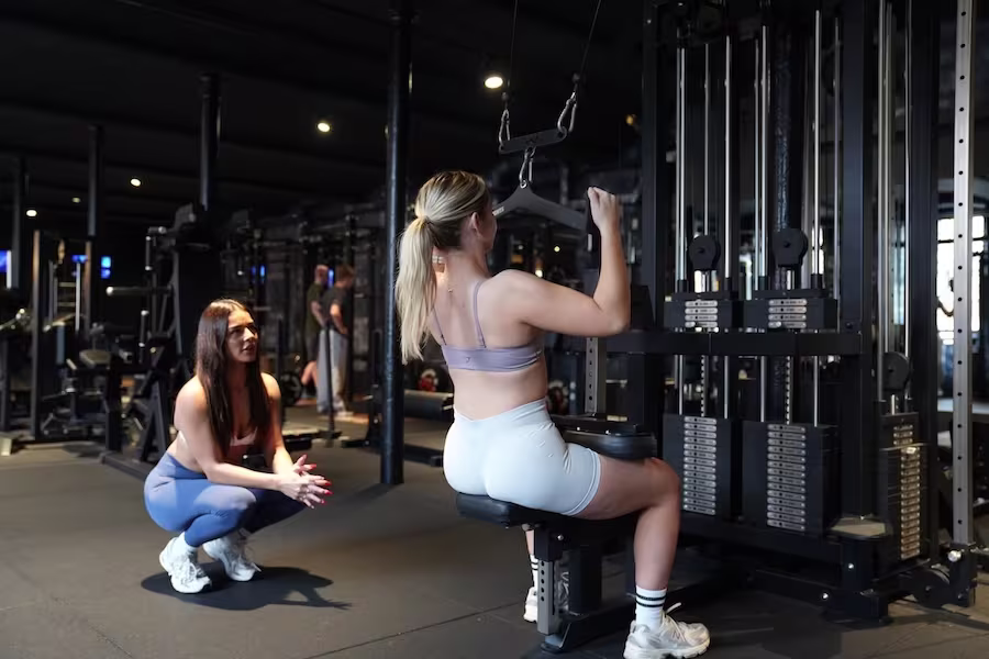 coach guides client through a side plank core exercise at ONE|DZ Gym