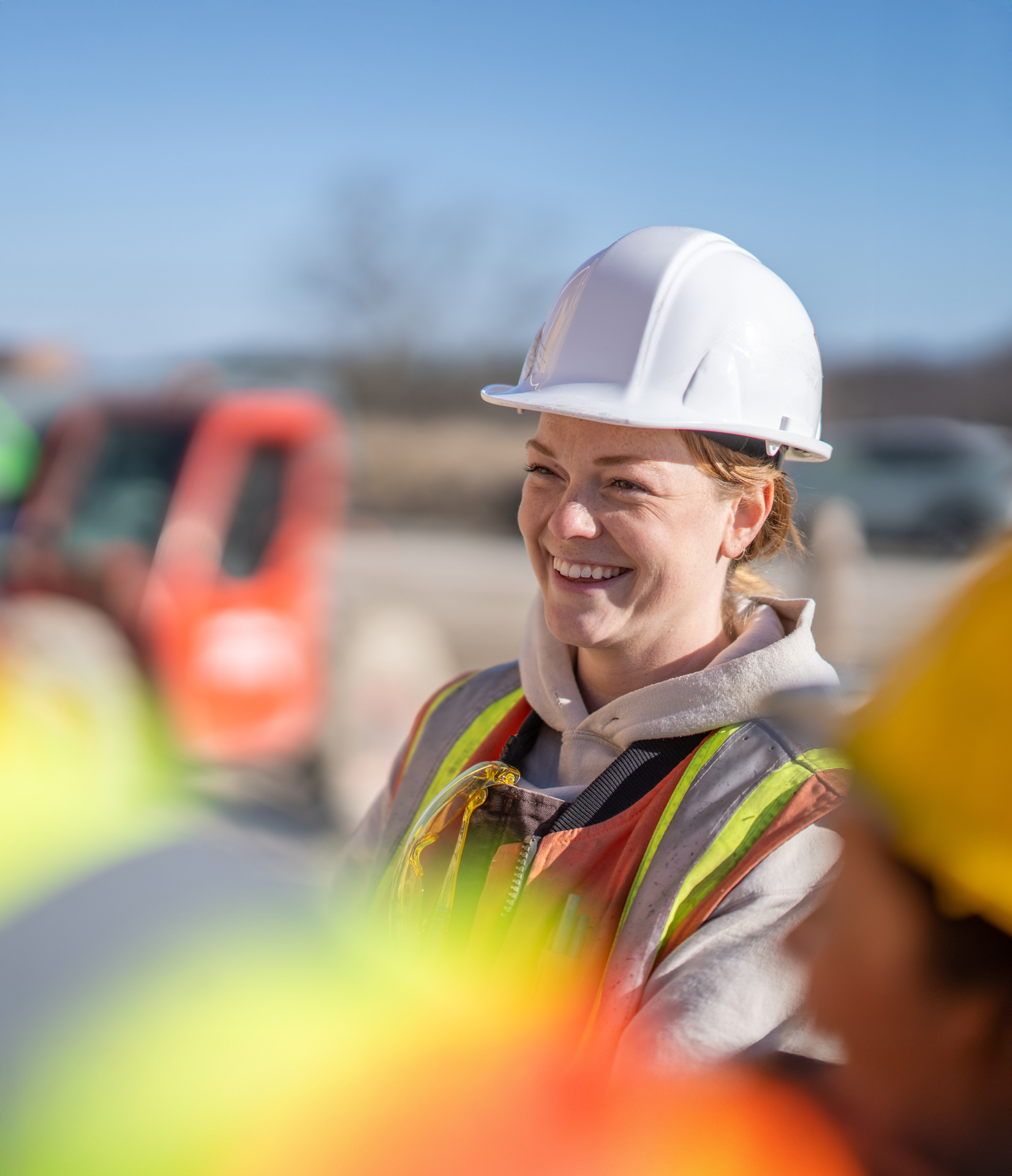female construction site worker smiling happily with coworkers