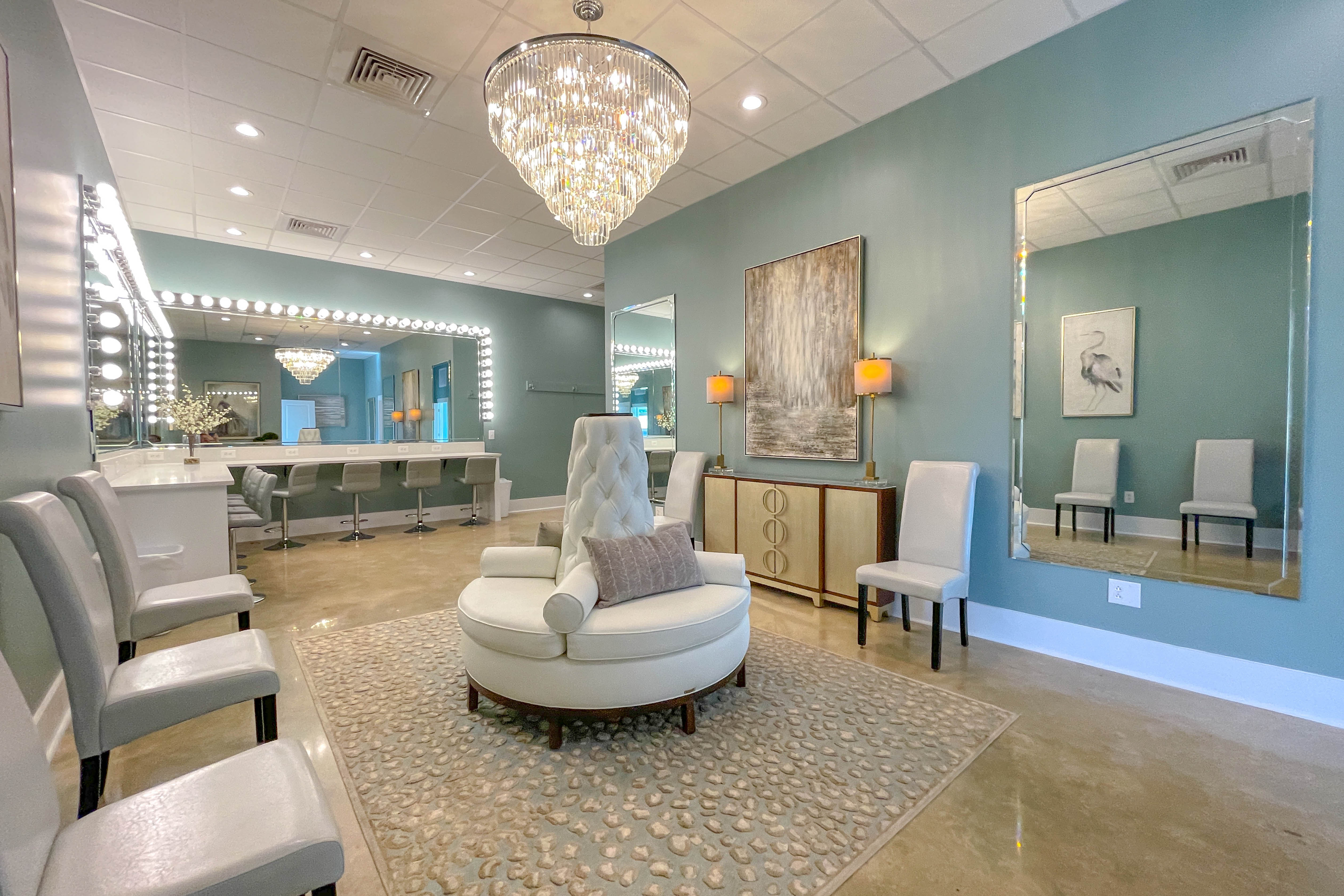 Elegant salon interior with crystal chandelier, mirrors, and mint green walls