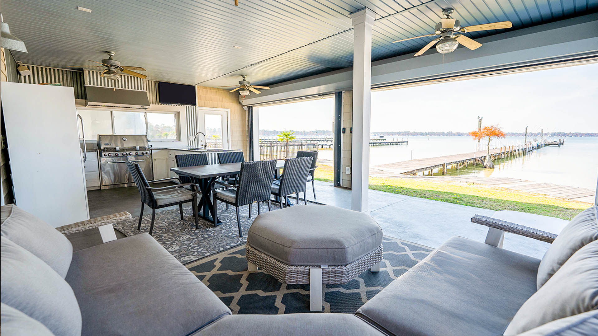 Modern indoor-outdoor living space with waterfront view and kitchen