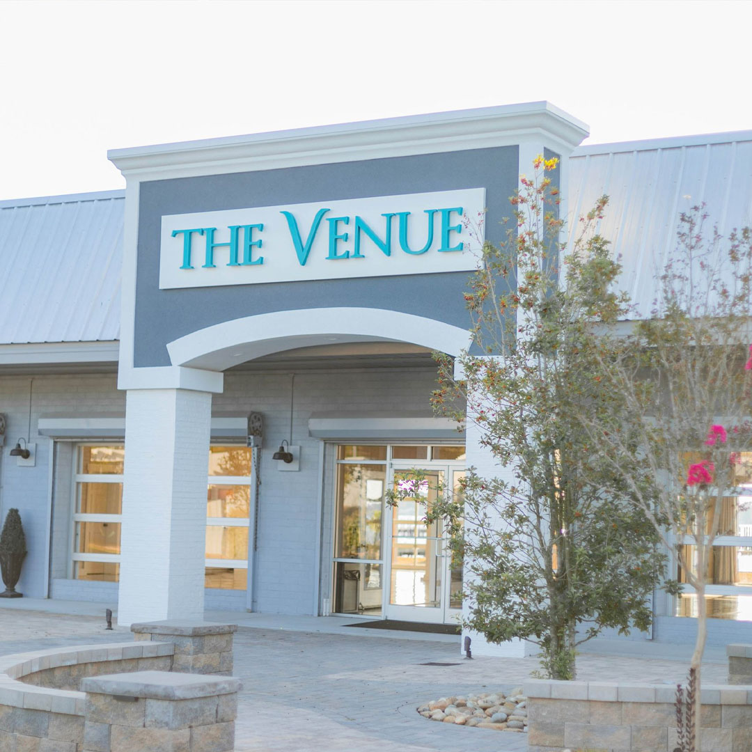 Exterior of The Venue building with blue signage and landscaped entrance