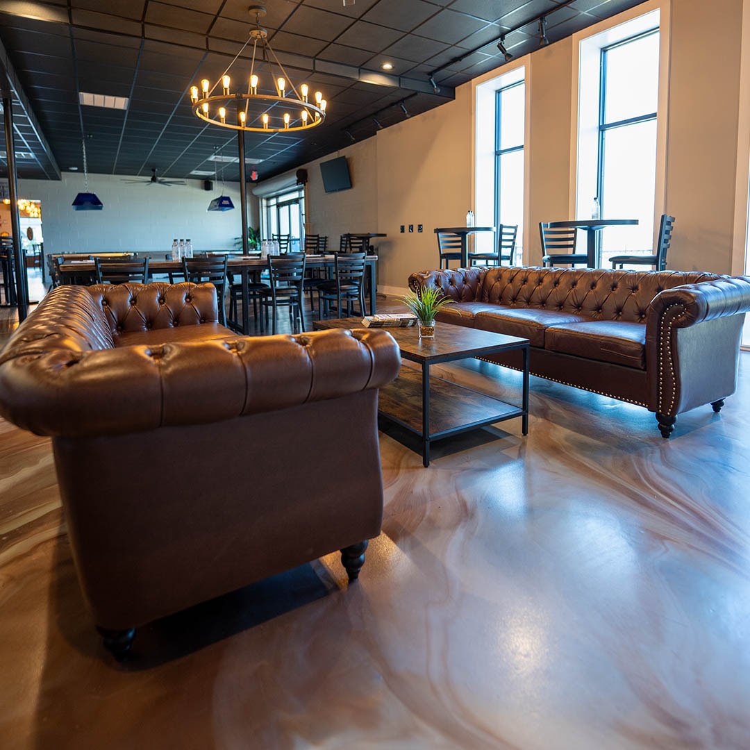 Cozy cafe interior with leather sofas, chandelier, and wooden tables