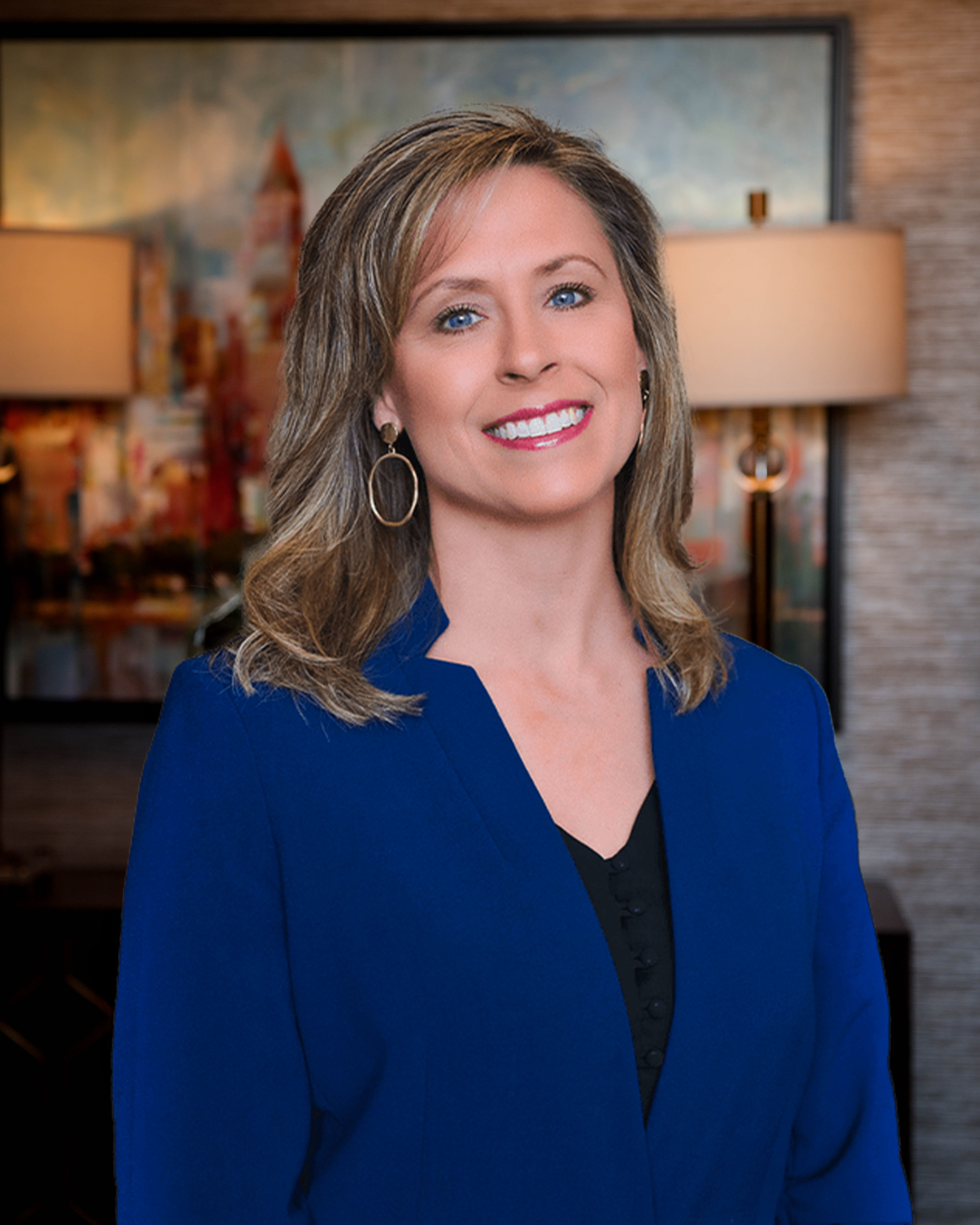 Professional woman smiling in blue blazer against warm indoor background