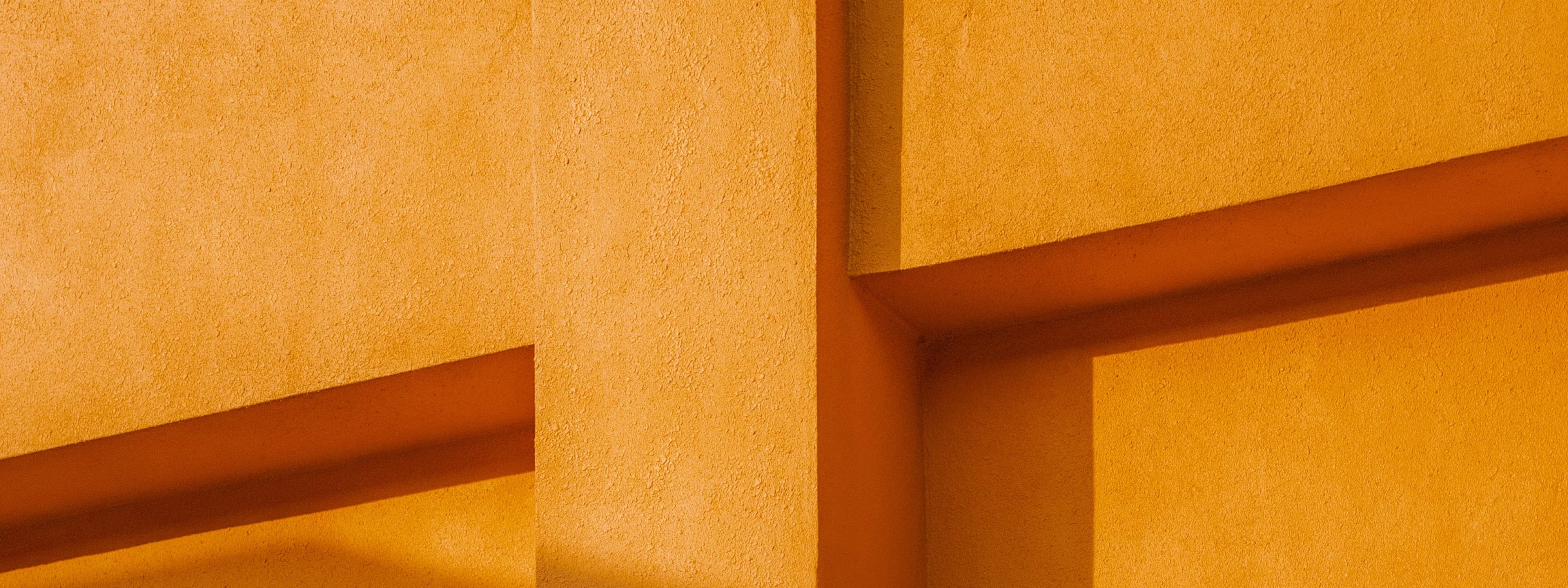Abstract geometric wall with orange and golden textured surfaces