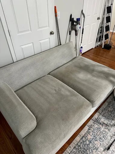 Gray sofa in a room with white doors and a wooden floor