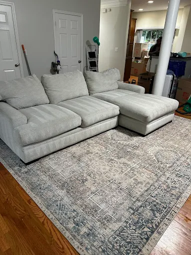 Gray sectional sofa with chaise on patterned area rug in living room