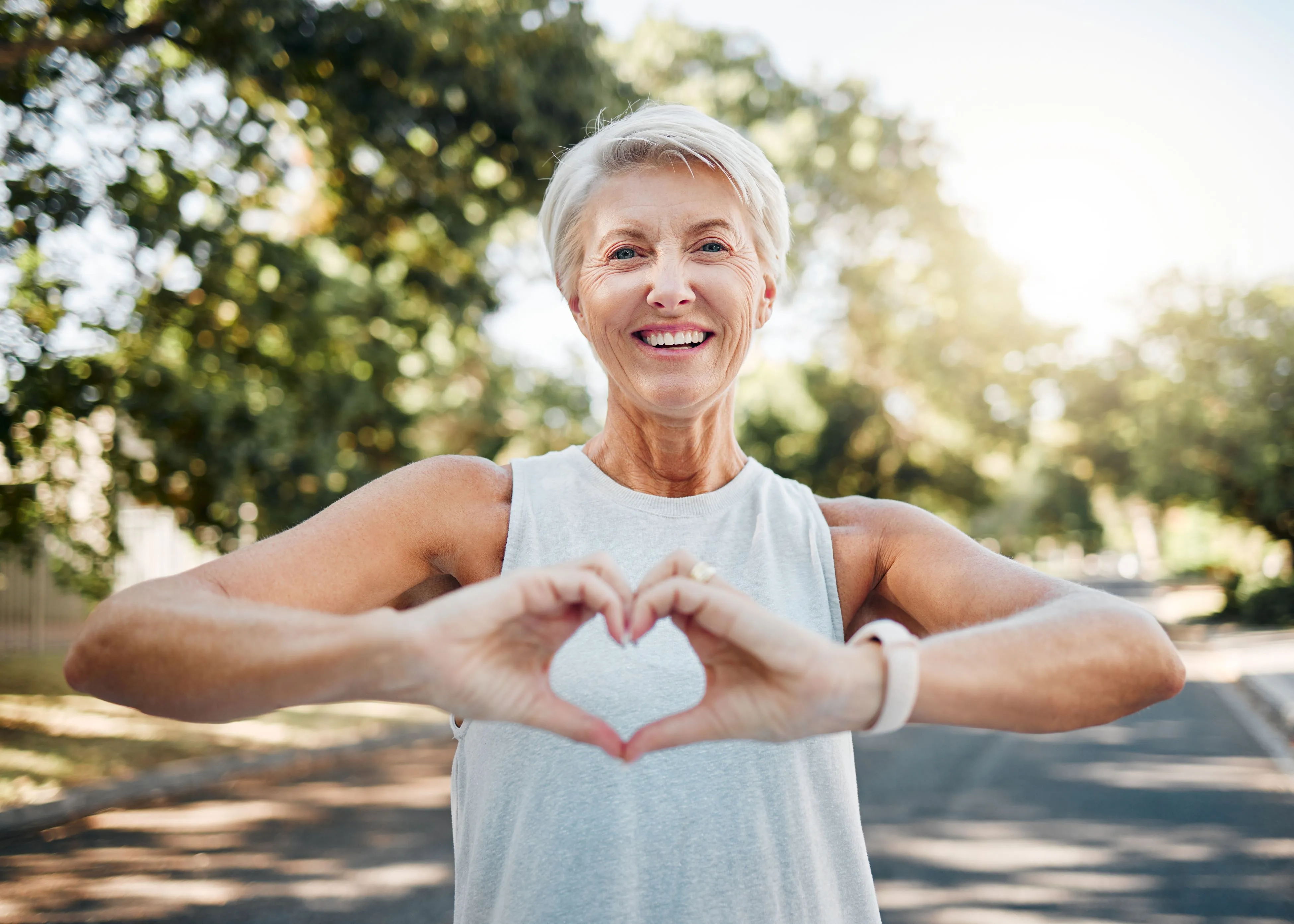 A woman making a heart shape with her hands.