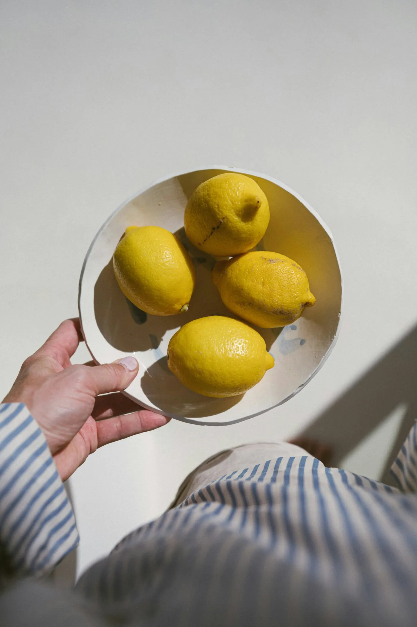 hand holding lemons striped shirt