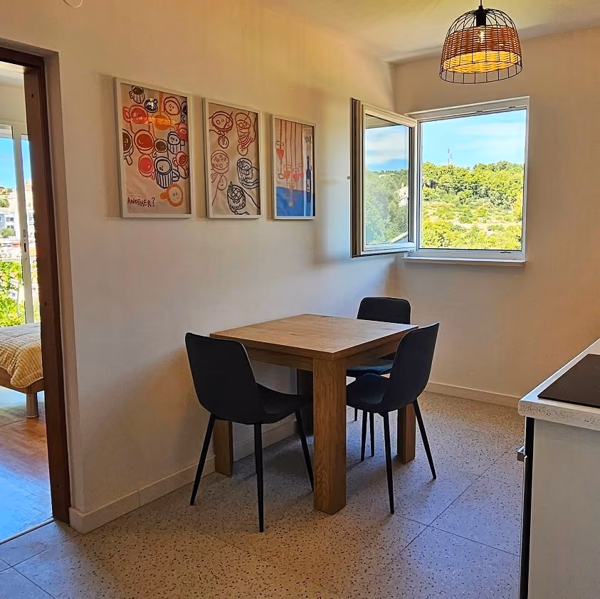 Villa Perla dining area with natural light and views of Mediterranean greenery in Okrug Gornji near Trogir