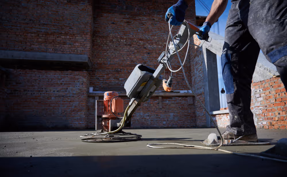 Worker finishing and smoothing a concrete surface