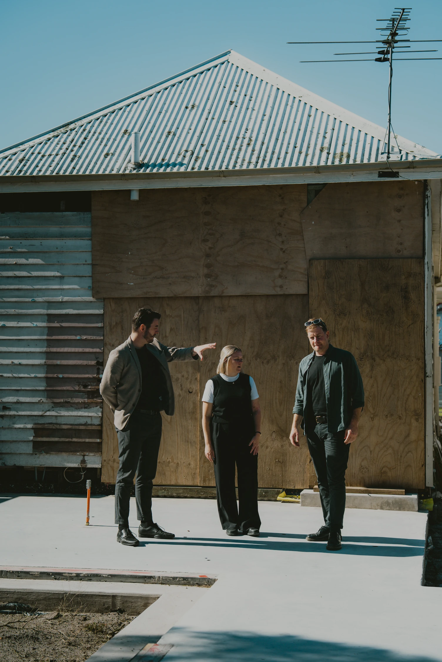 Three people talking on house building site