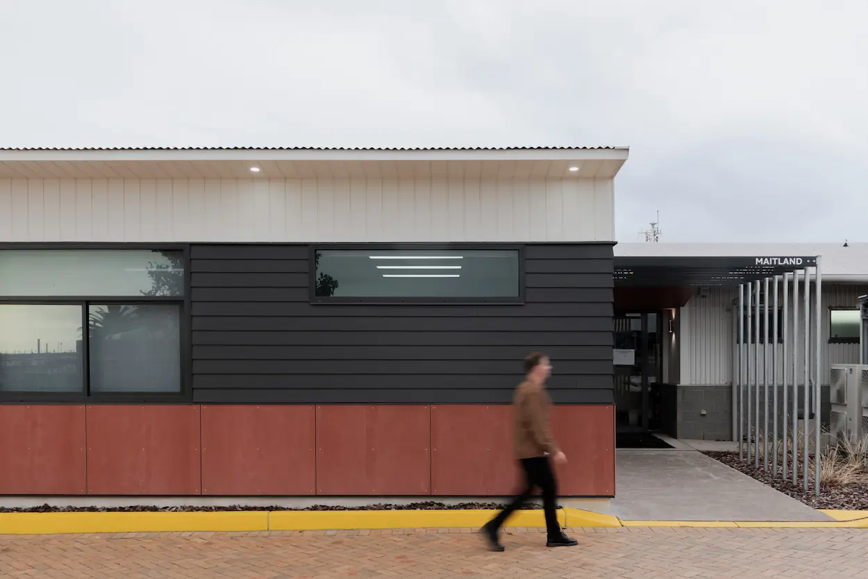 Blurred man walking in infront of brown building