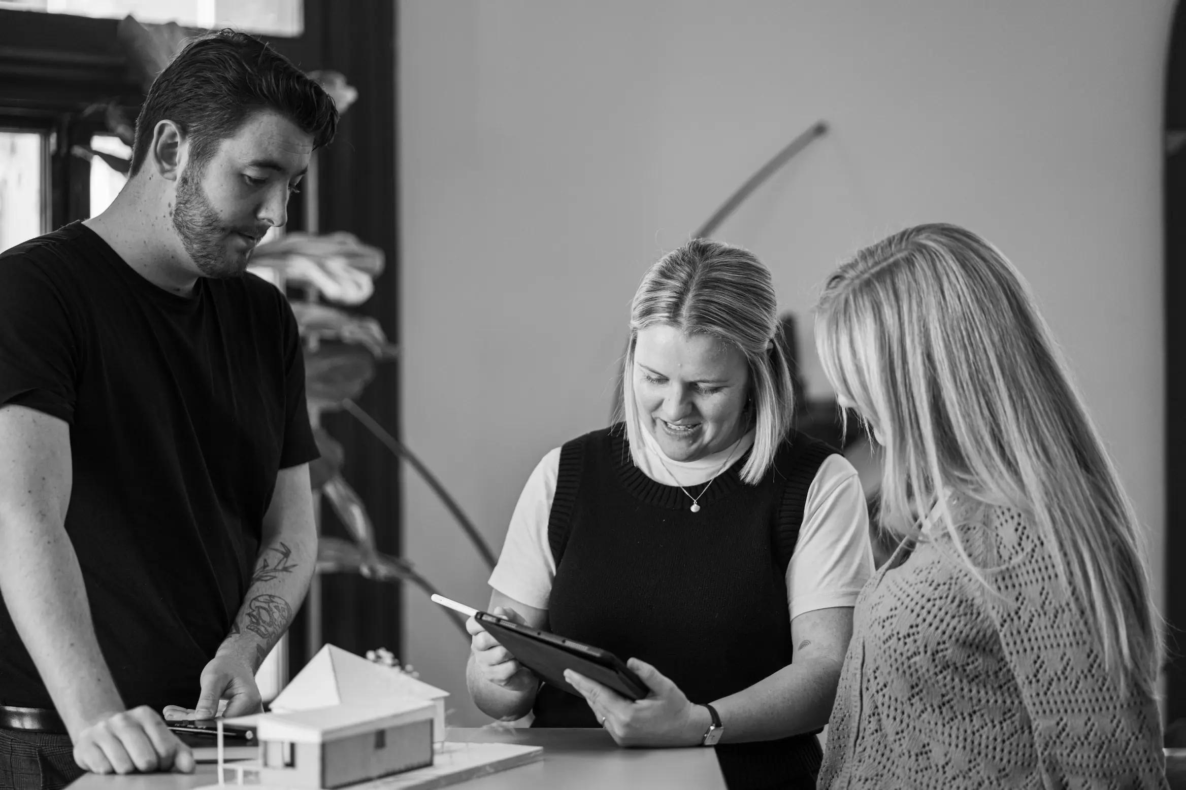 Three people talking about model home and ipad