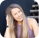 Smiling woman with long blonde hair wearing a purple top