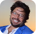 Smiling man in blue jacket against gradient background, looking cheerful