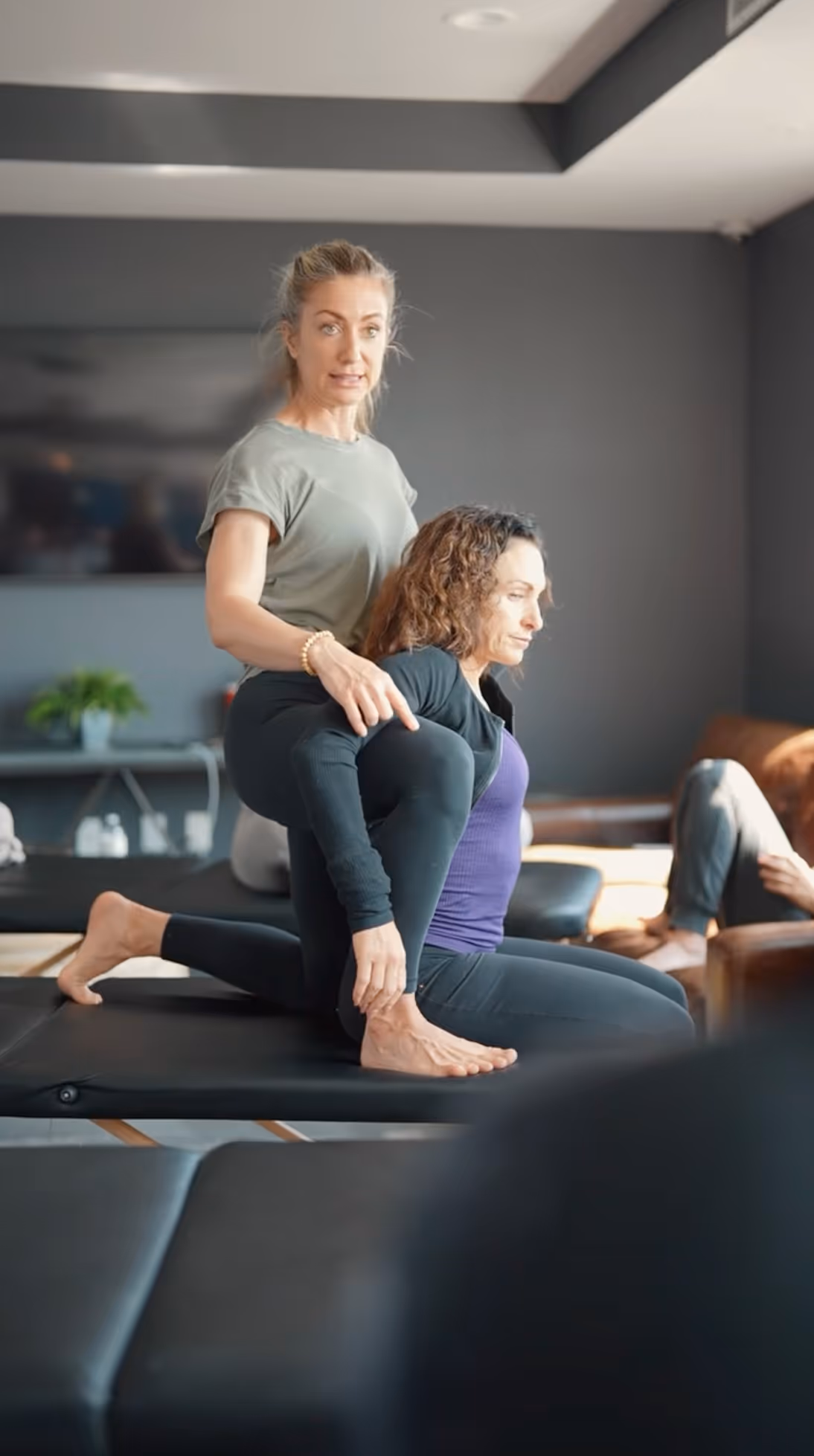 Instructor helping client with stretching pose during physiotherapy session