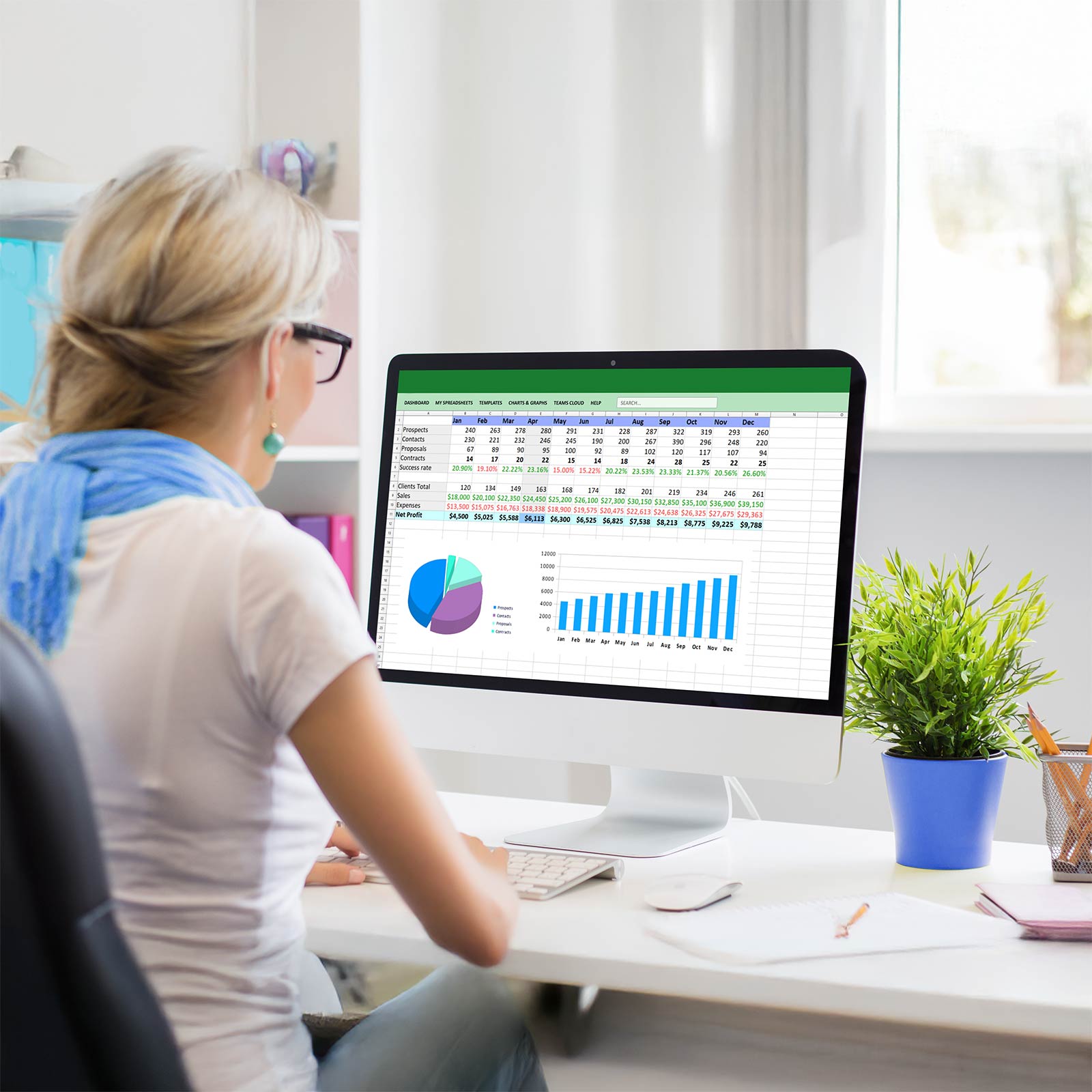 A finance person sitting at her desk running through a spreadsheet