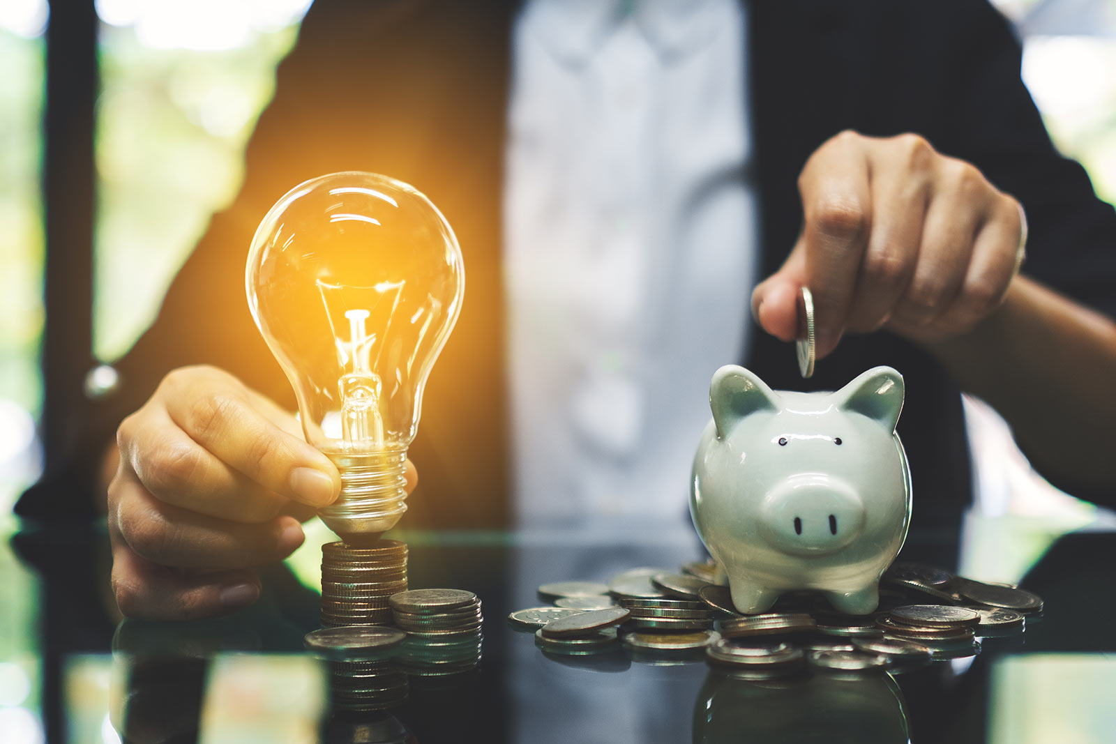 Person adding coins into a piggy bank