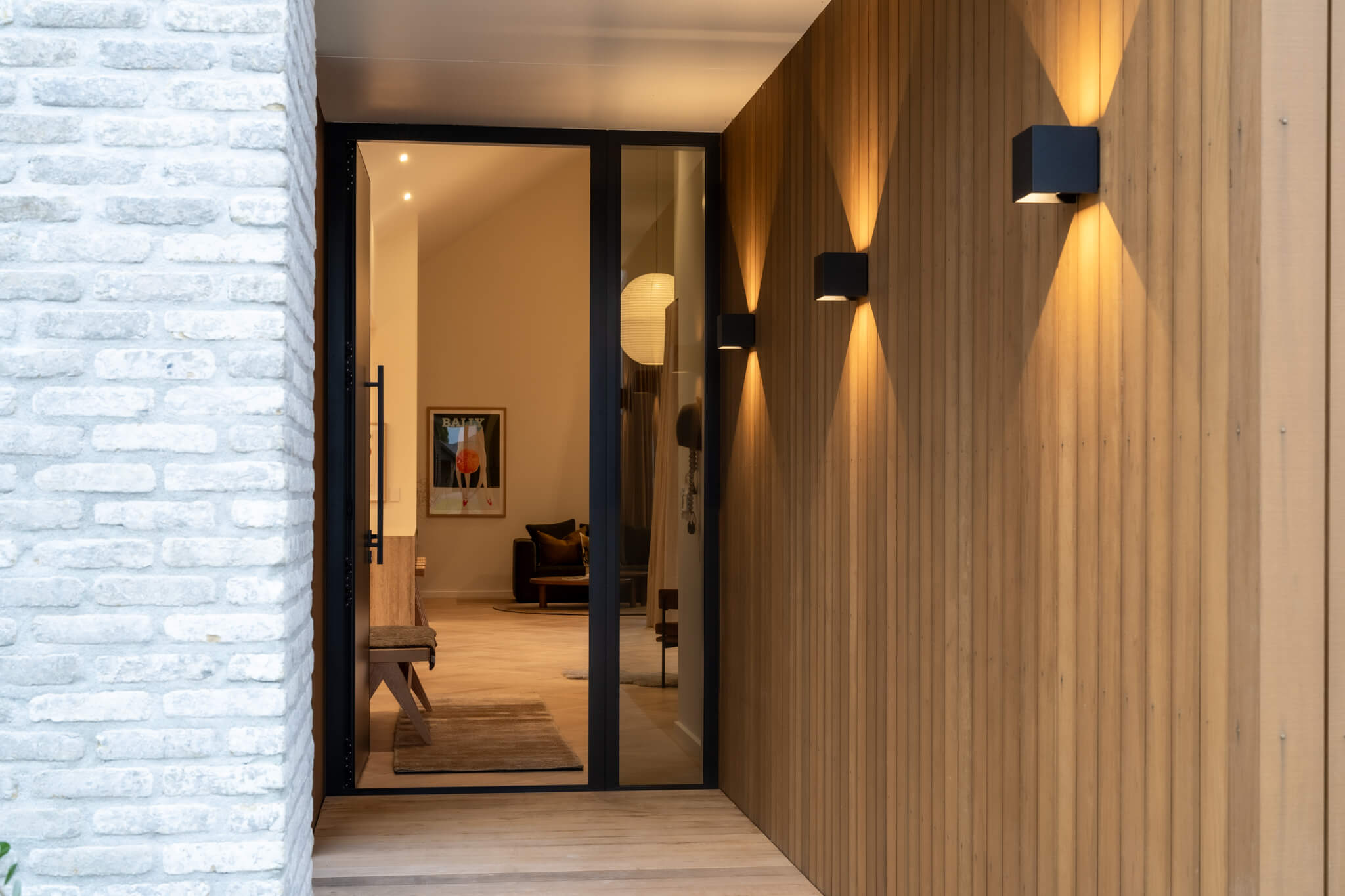 Modern entryway with wooden panel walls and soft lighting. 
