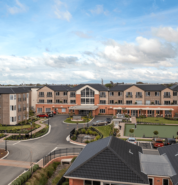 Aerial view of a modern, multi-story retirement home with red brick facade.