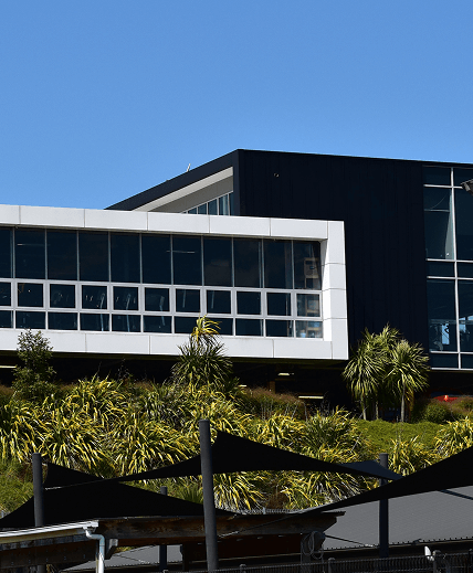 Modern commercial building with large windows under a clear blue sky.