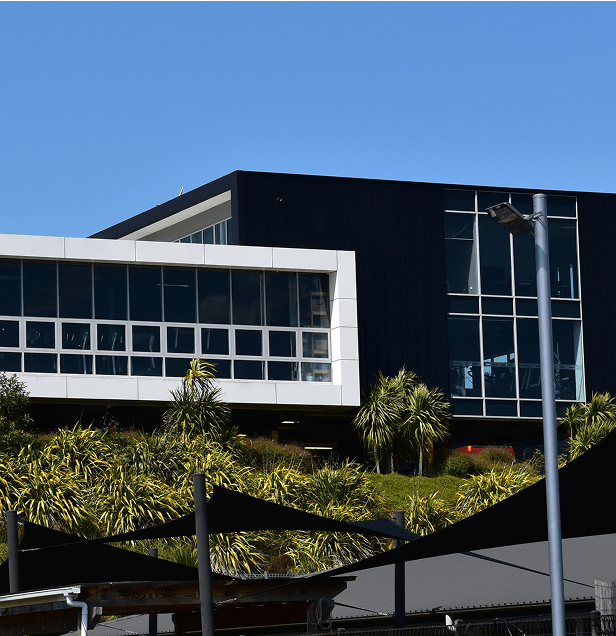 Modern commercial building with large windows under a clear blue sky.