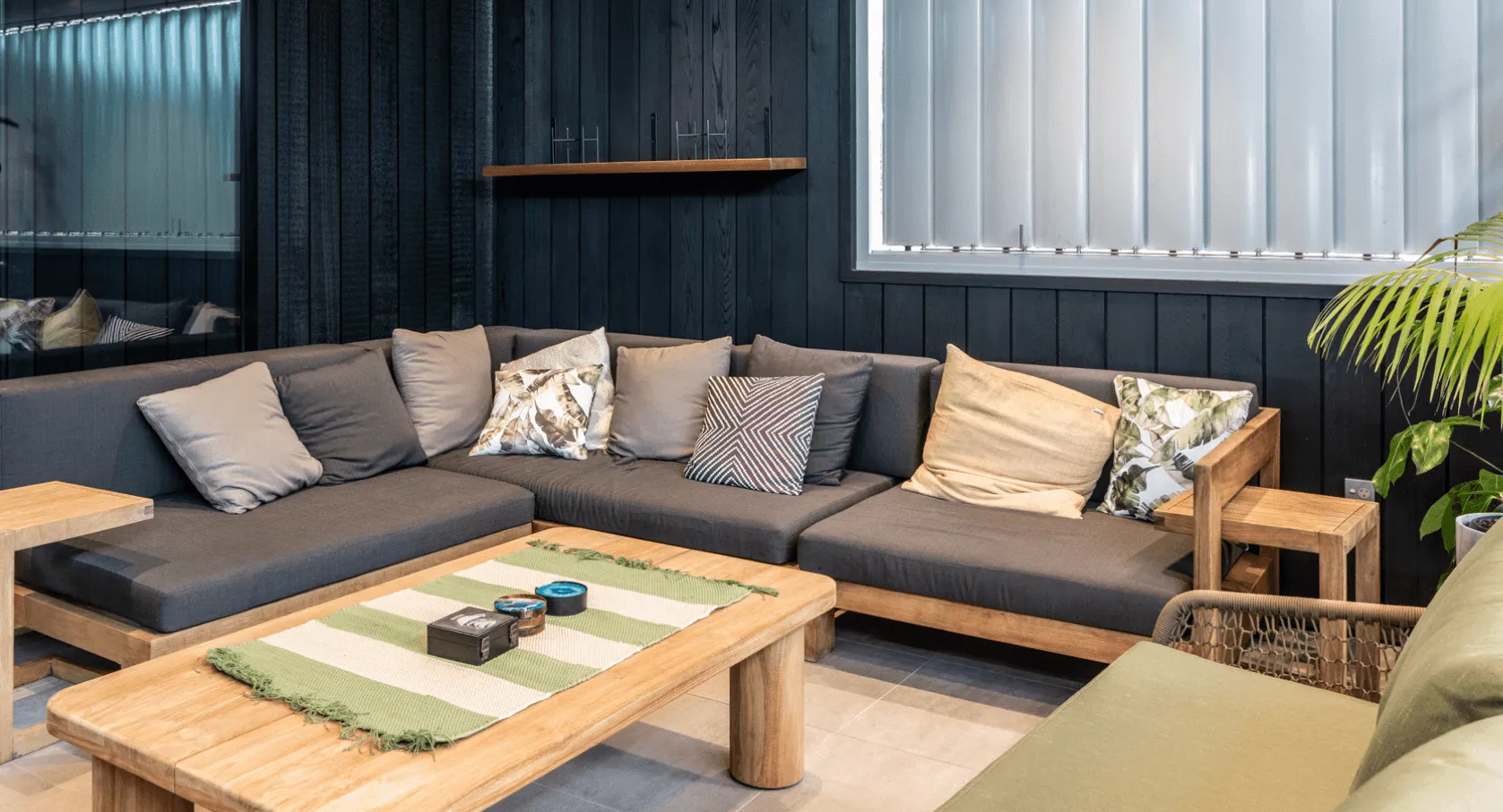 A cozy living room with a dark gray sectional sofa adorned with patterned cushions.
