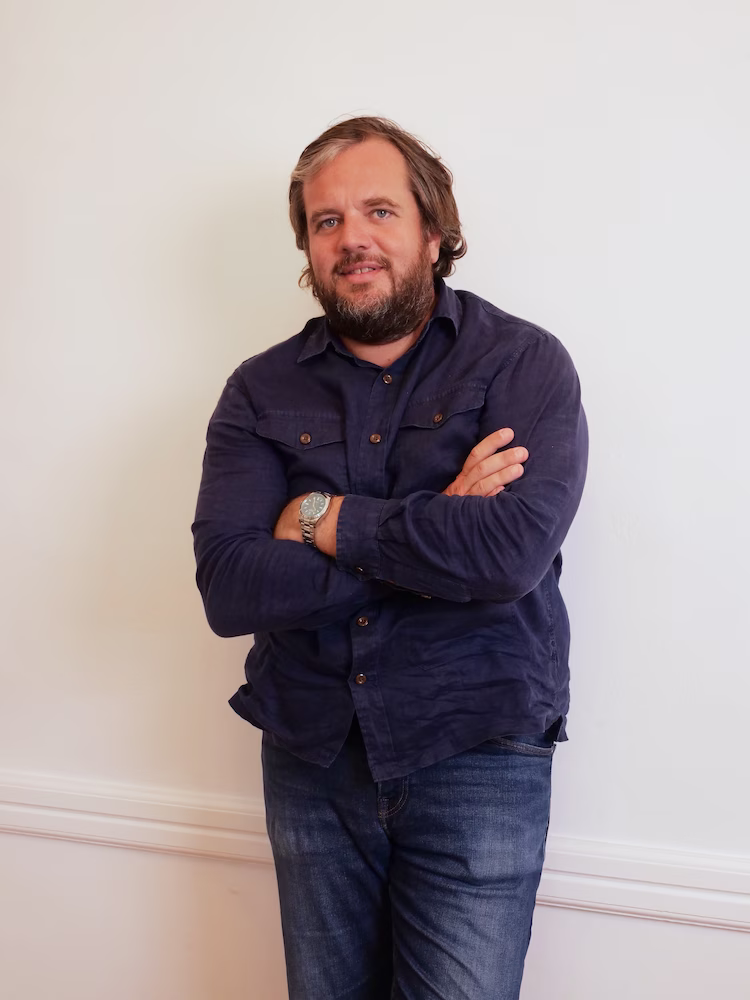 Une photo de Benjamin Gaignault avec un mur blanc en fond