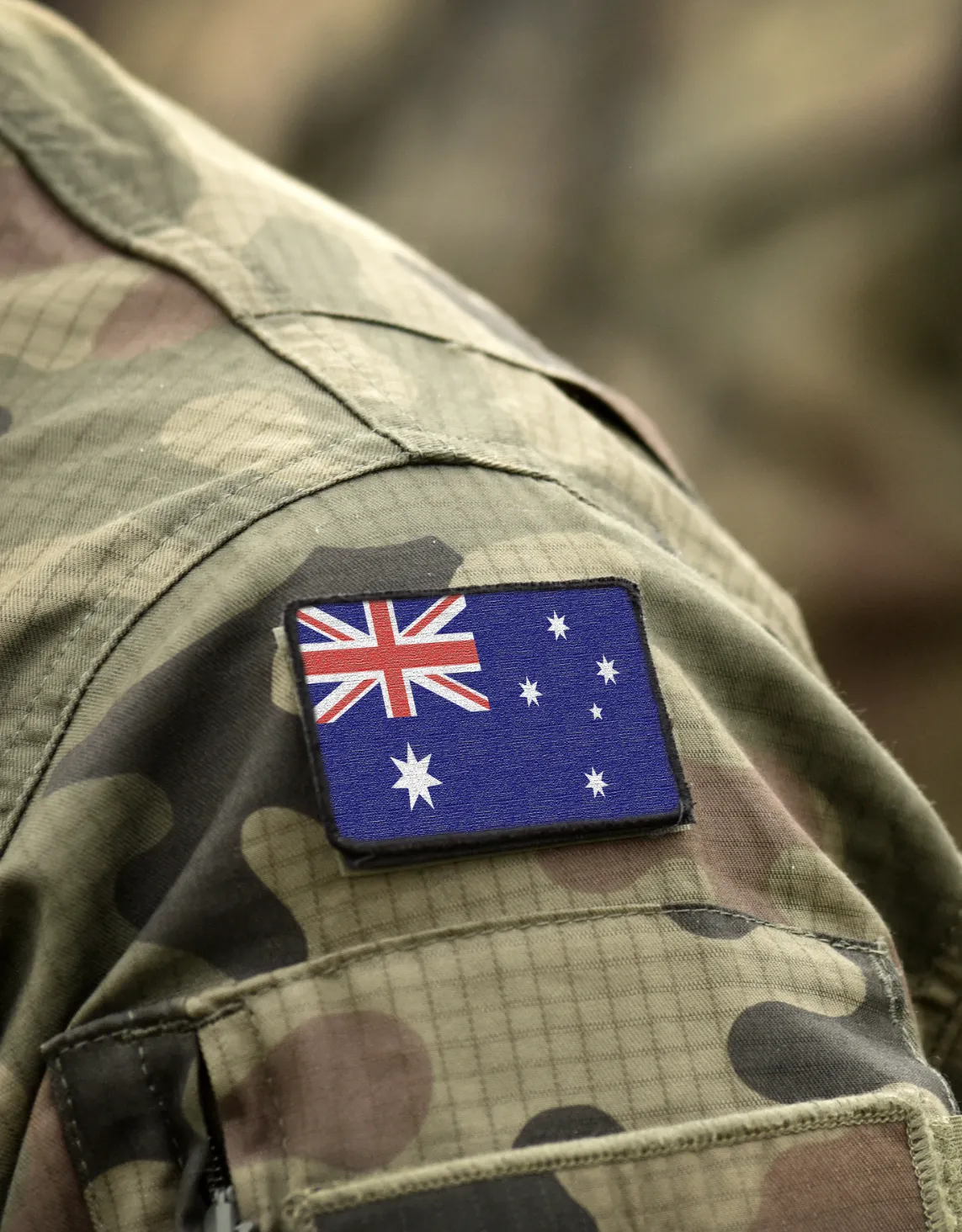 Close-up of an Australian flag patch on a military camouflage uniform, representing DISP membership requirements and Essential Eight Maturity Level 2 compliance for defence industry suppliers