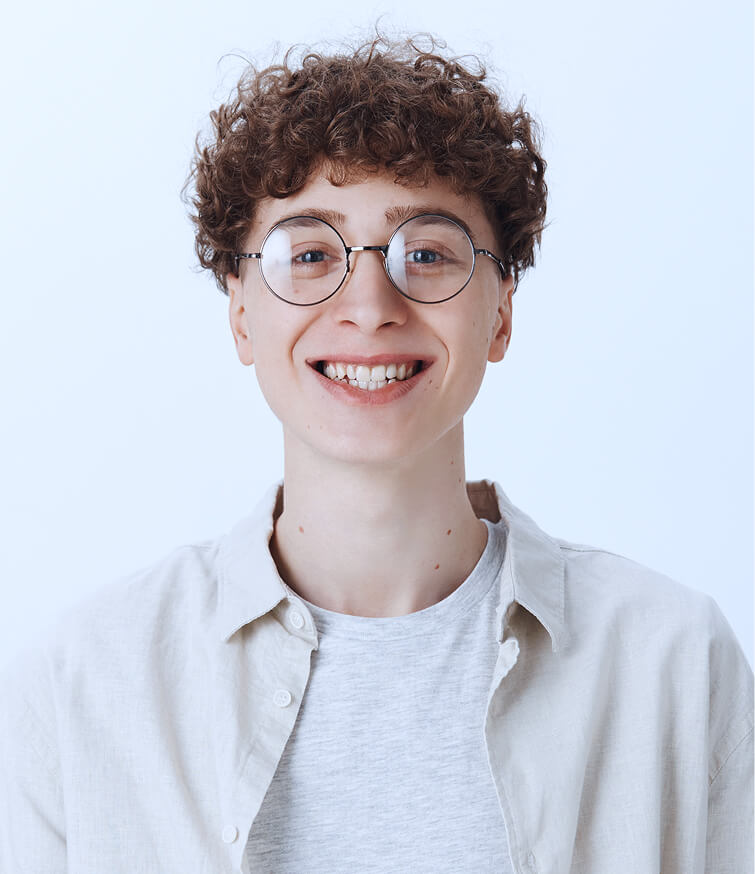 cheerful attractive teenage guy posing against white wall