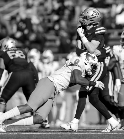 Football player making a clutch catch under pressure – symbolizing the precision and drive Red Envelope Sports Agency looks for in rising talent.
