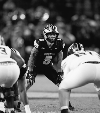 Football player making a clutch catch under pressure – symbolizing the precision and drive Red Envelope Sports Agency looks for in rising talent.