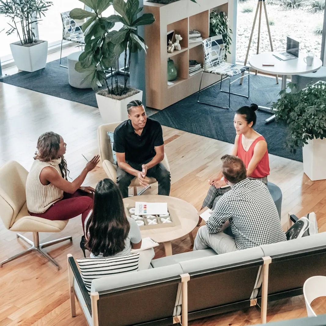 Team sitting in modern office lounge having a casual meeting