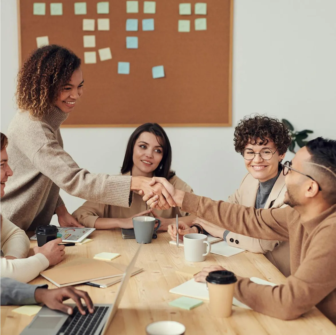Team high-fiving in casual meeting room, showcasing positive company culture