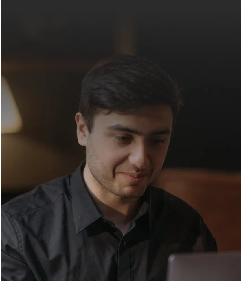 Smiling professional working on laptop, suggesting career opportunity