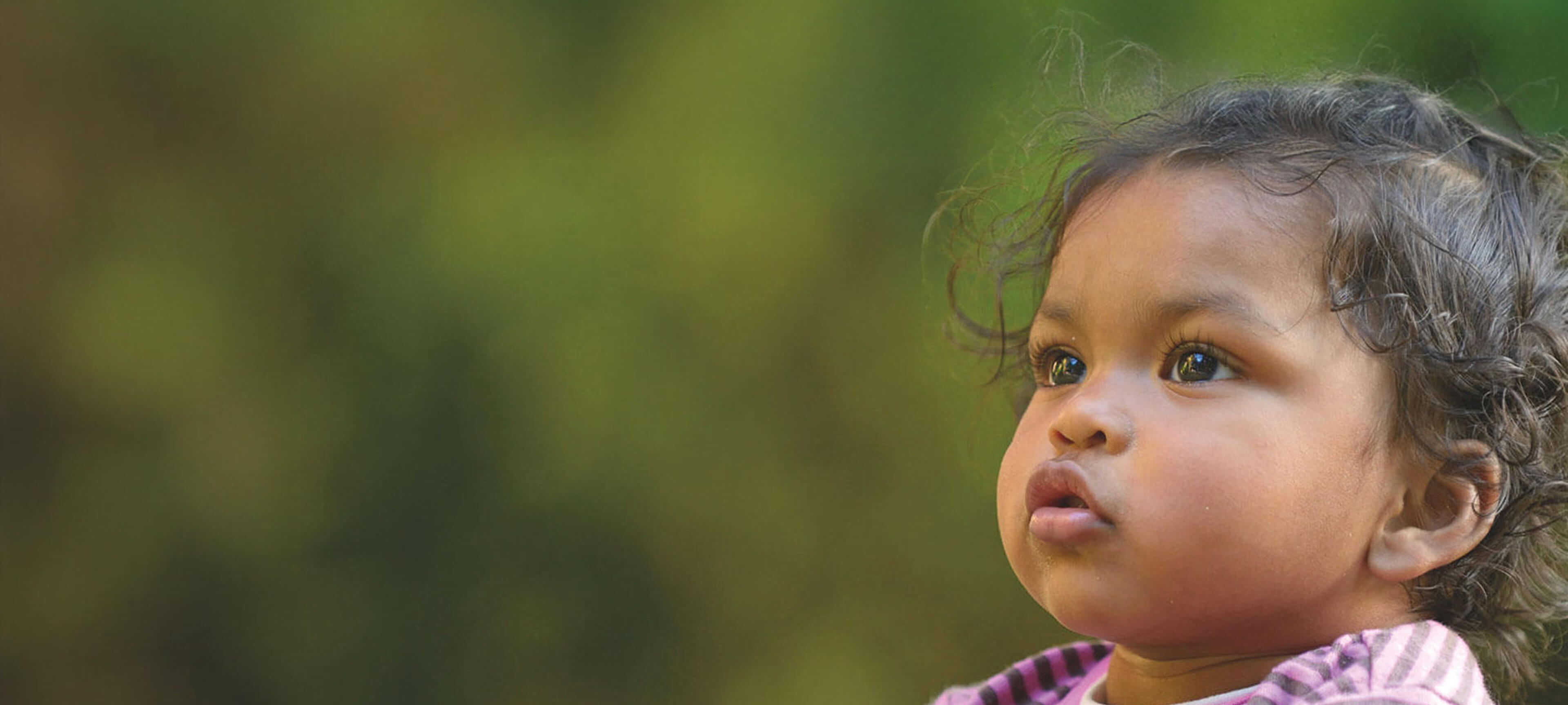 Portrait of a young child looking upward with curiosity and hope, symbolizing the impact of life-changing medical technologies