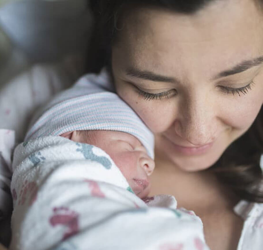 A woman holding her newborn baby