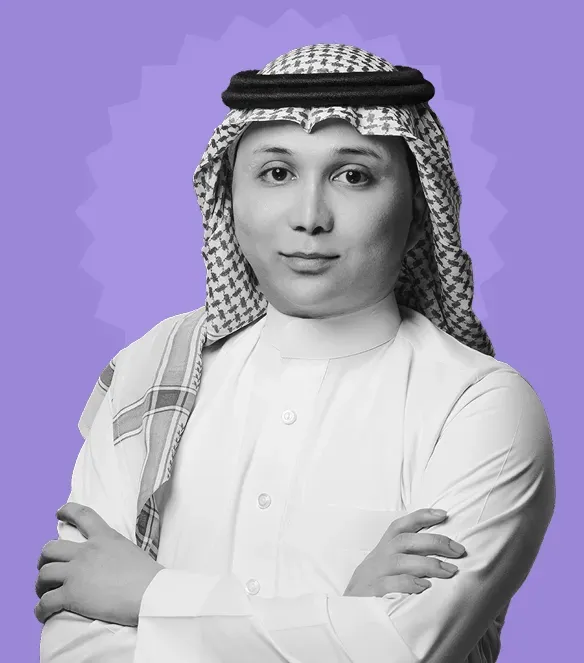Portrait of a man wearing traditional Middle Eastern attire with a checkered headscarf and white thobe, arms crossed.