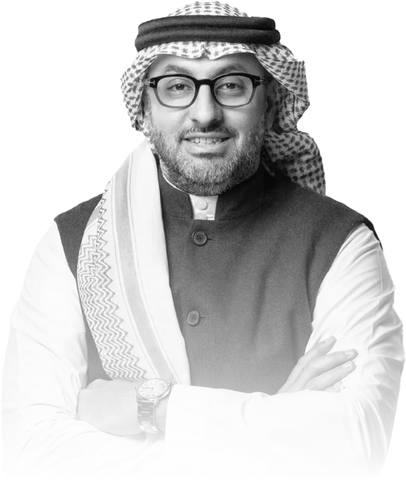 Smiling middle-aged man wearing traditional Middle Eastern attire, glasses, and a wristwatch, with arms crossed.