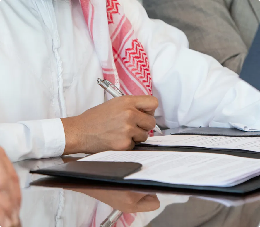 Person using a blue self-inking stamp on a printed document on a white desk.