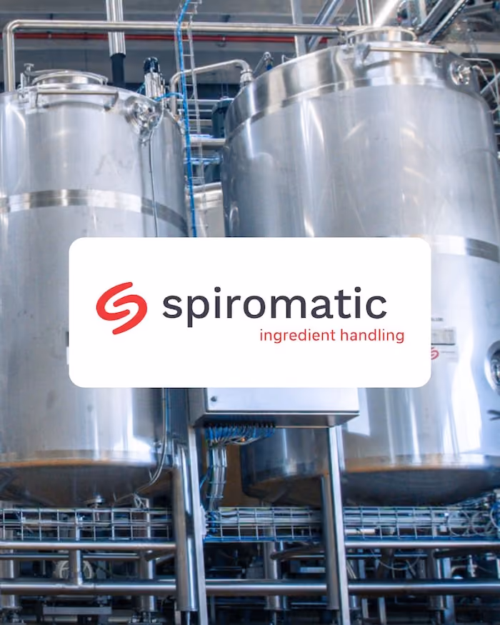 Logo de Spiromatic ingredient handling sur une photo de silos en inox dans un site de production