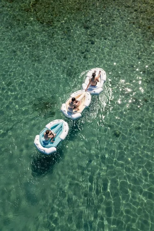 Drone shots of 3 Darth Craft watercrafts floating in a clear water one behind another